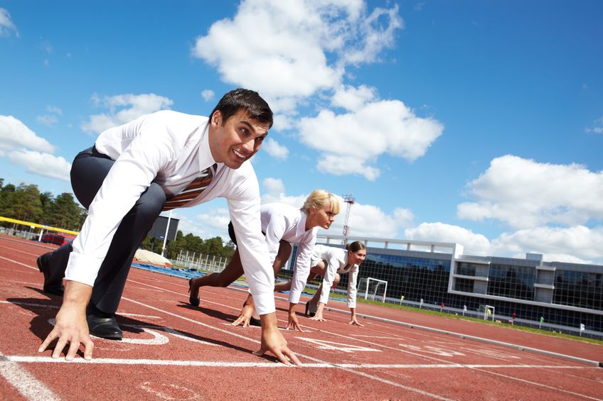 row of business people getting ready for race with man at foreground