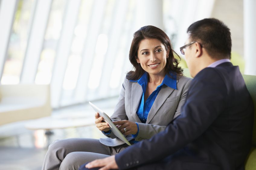 businesspeople with digital tablet sitting in modern office