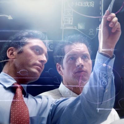 Analyze and Assess Two men analyzing a complex diagram