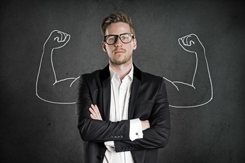 business man standing in a confident manner flexing his muscles