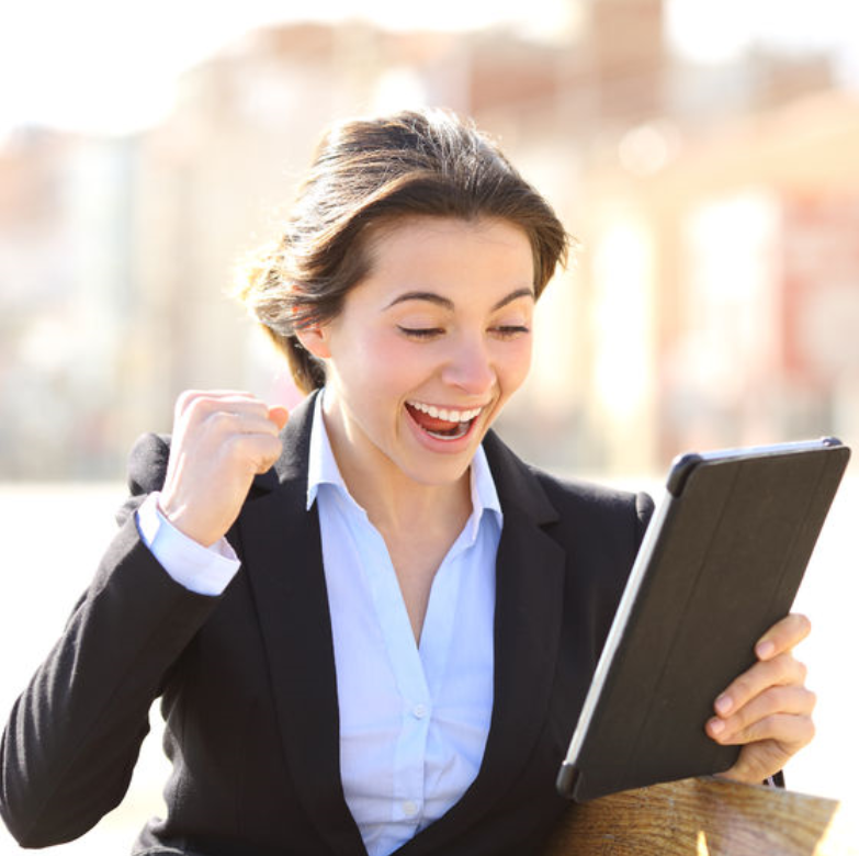 excited woman looking at tablet pumping fist in air