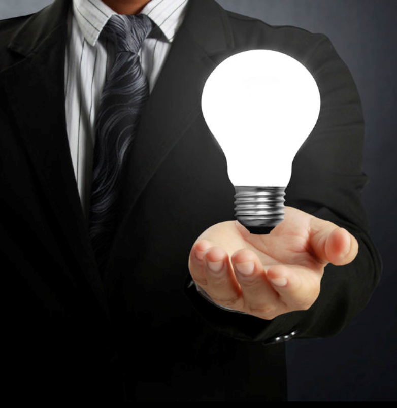 business man holding a light bulb in palm of hand