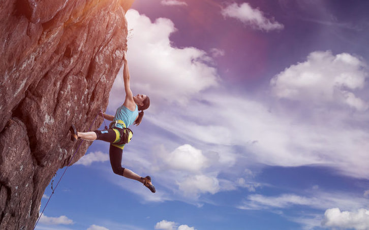 woman hanging over the side of a cliff